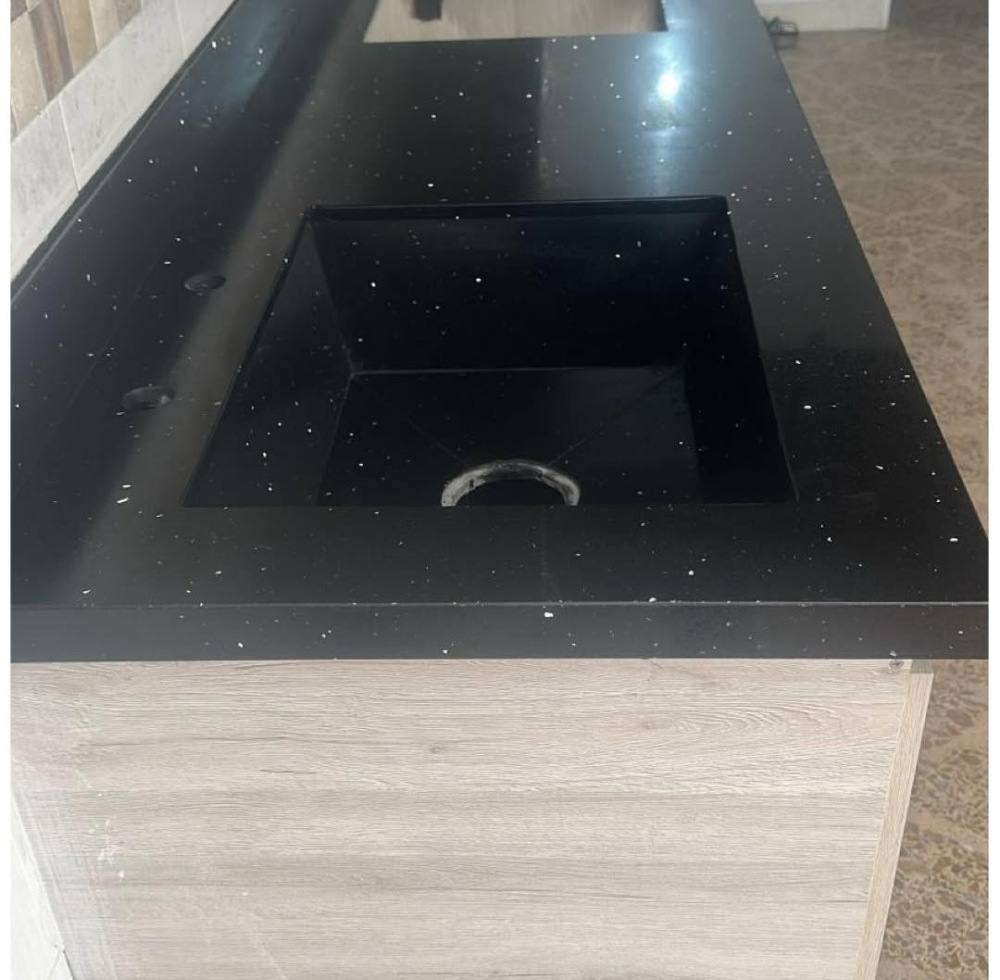 Mesón en granito negro estrellado con poceta cuadrada y base de madera clara